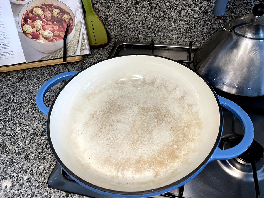 A cast Iron shallow casserole dish on a stove