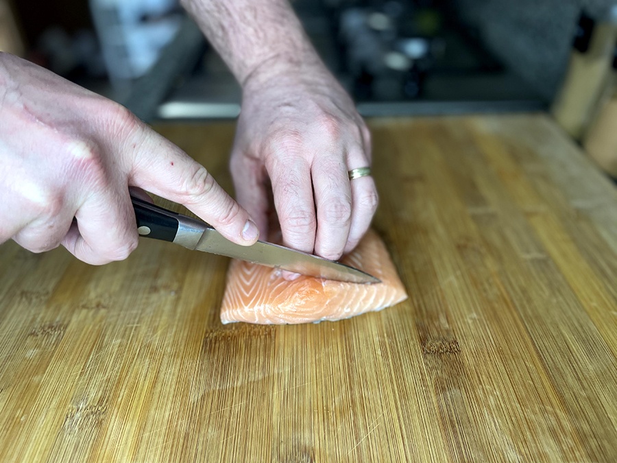 A chef cutting some salmon on a chopping board