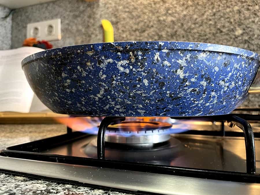 A blue pan om a gas hob