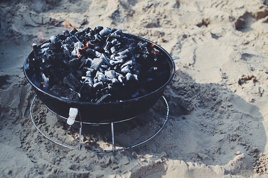 A charcoal grill on sand